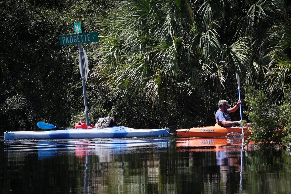 MATLACHA, FLORIDA - OCTOBER 1: A resident paddling a kayak returns to his home with supplies in a neighborhood flooded by a rising Myakka River in the wake of Hurricane Ian on October 01, 2022 in North Port, Florida. The Category 4 hurricane brought high winds, storm surge and rain to the area causing severe damage. (Photo by Win McNamee/Getty Images)