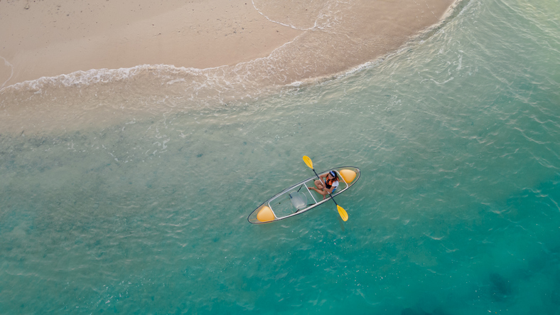 blue sea beach with floating kayak